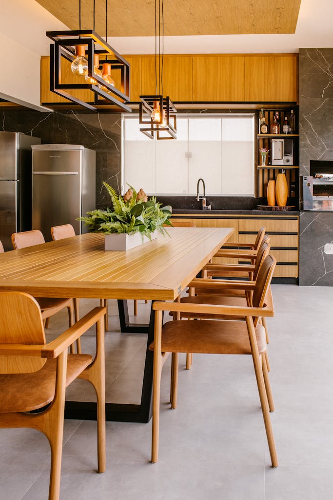 a dining tablein a beautiful kitchen with custom cabinetry by a peninsula general contractor with chairs and a refrigerator in the background
